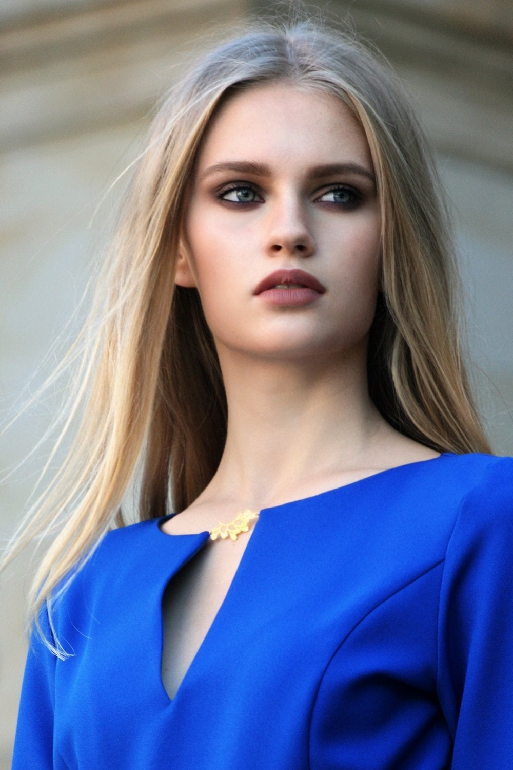 Blue long dress with pleats. Golden color detail in neckline