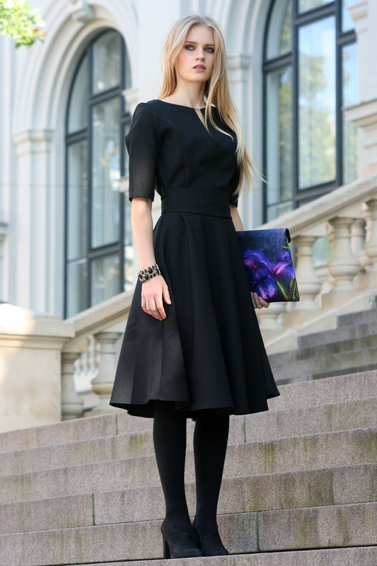 Black dress with circle skirts. Golden color detail in neckline