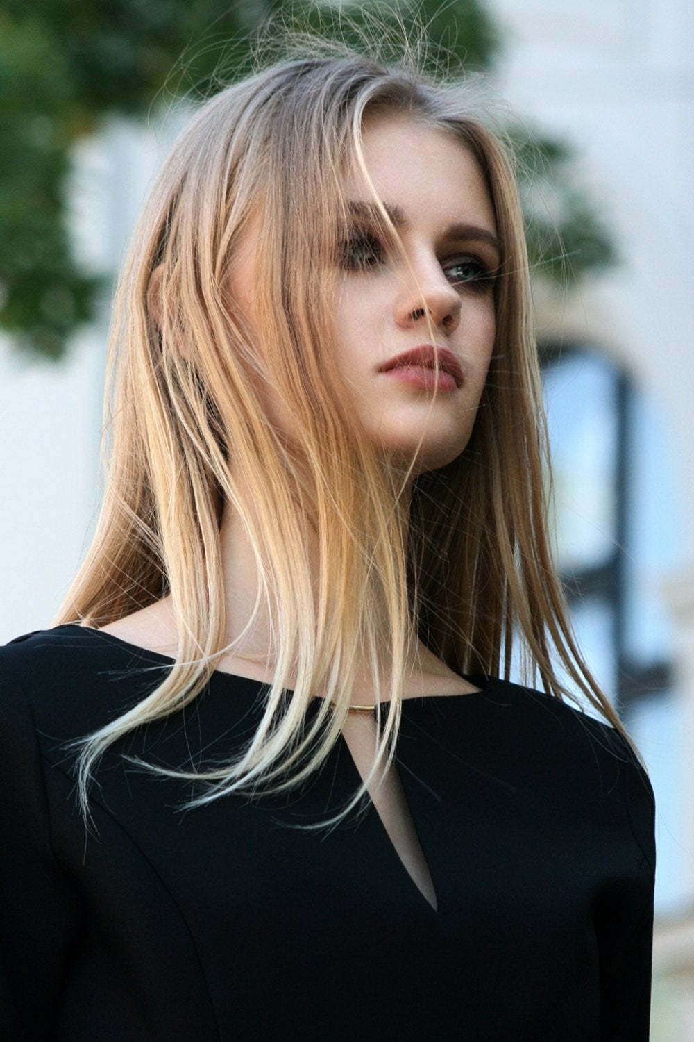 Schwarzes Kleid mit Kreisröcken. Goldfarbenes Detail im Ausschnitt