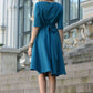 Blue green dress with circle skirts. Golden color detail in neckline