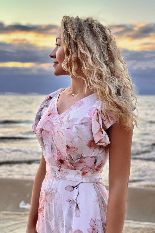 Pink floral viscose dress with puff sleeves, seaside portrait