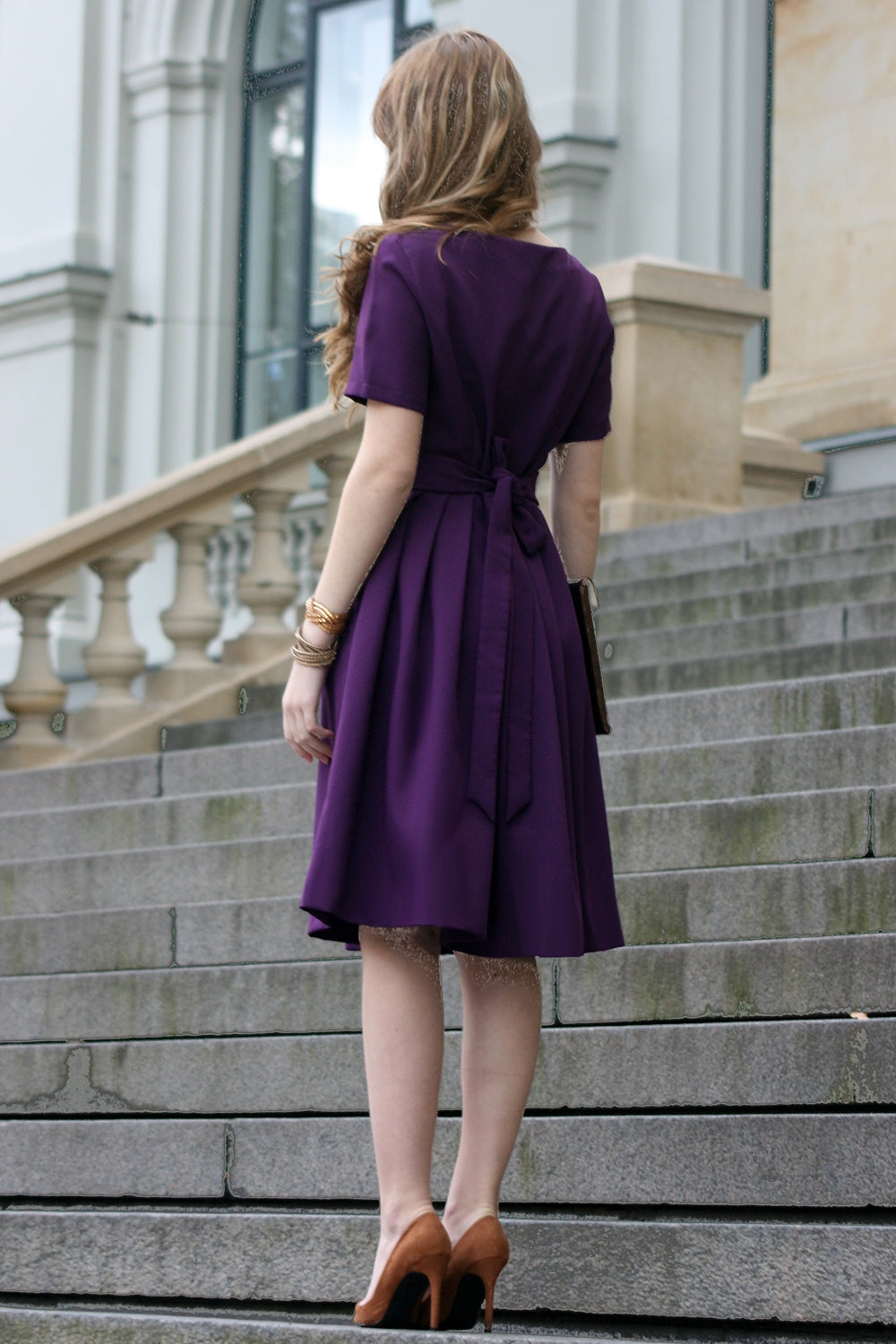 Volles lila Kleid mit Falten. Golddetail am Ausschnitt