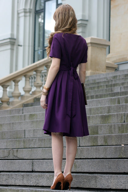Volles lila Kleid mit Falten. Golddetail am Ausschnitt