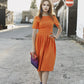 Orangefarbenes Kleid mit Falten 