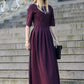 Long dress in grape shade with pleats. Golden color detail in neckline