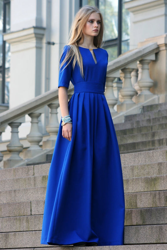Blaues langes Kleid mit Falten. Goldfarbenes Detail im Ausschnitt 
