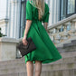 Green dress with circle skirts. Golden color detail in neckline