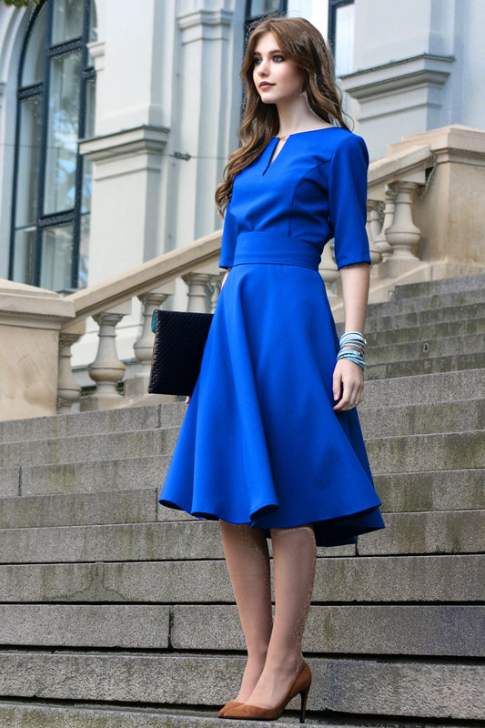 Blaues Kleid mit Kreisröcken. Goldfarbenes Detail im Ausschnitt 