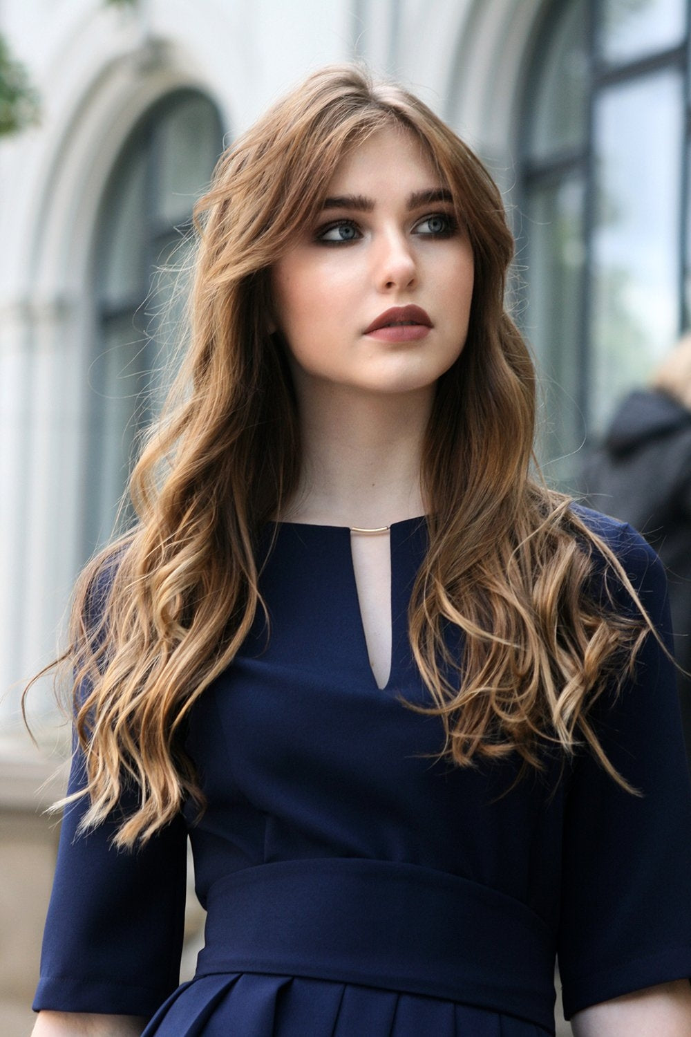 Long dark blue dress with pleats. Golden color detail in neckline