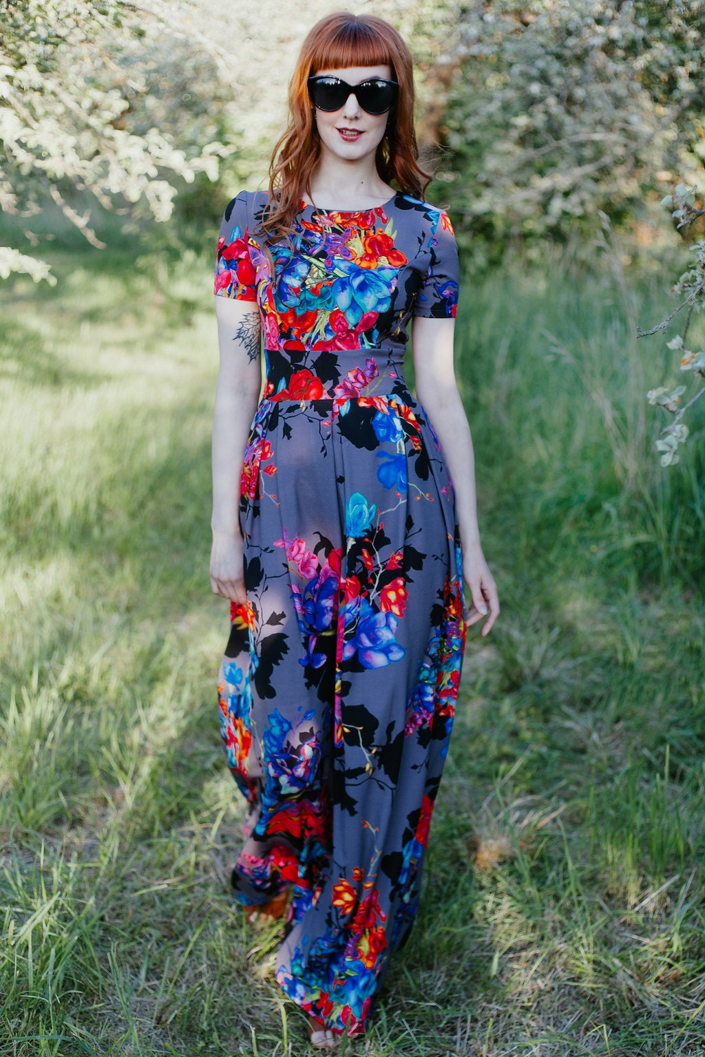 Pelēka gara kleita ar krāsotiem košiem ziediem