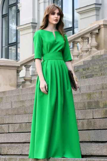 Green maxi dress with pleats. Golden color detail in neckline